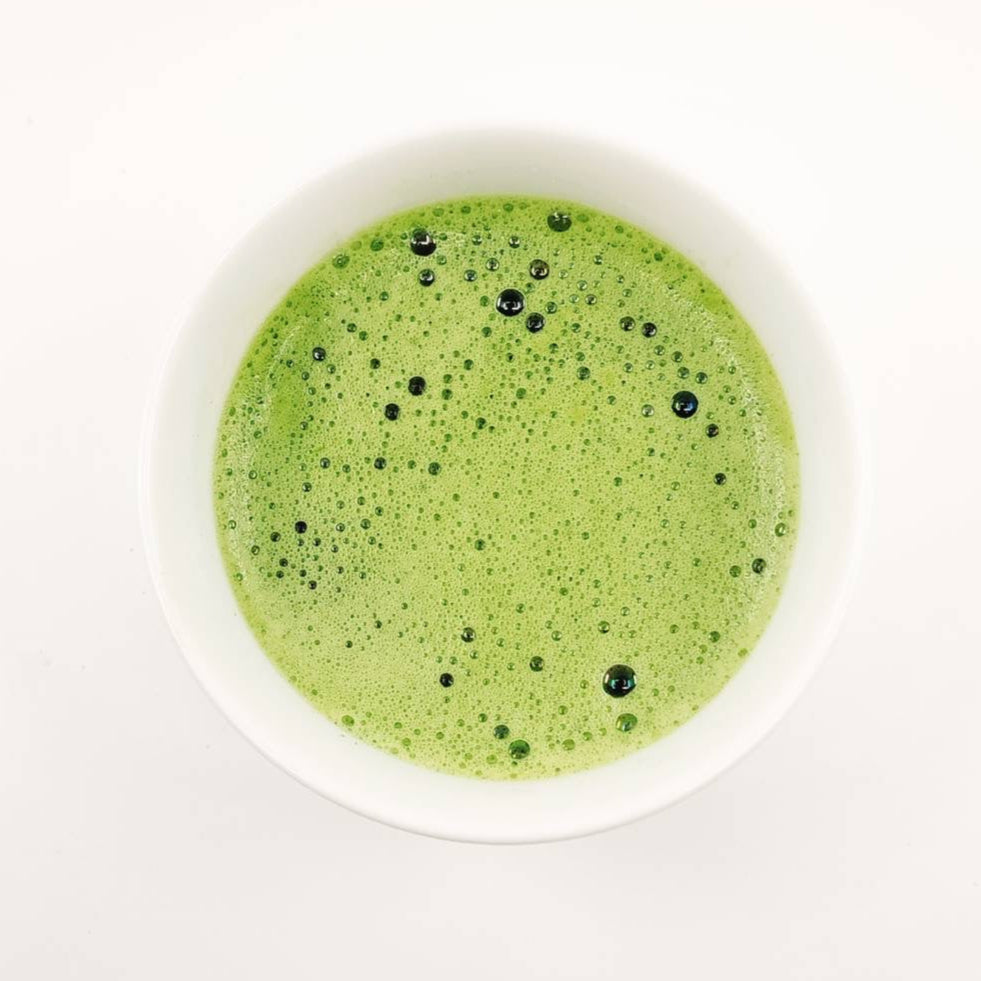 Green smoothie in a white bowl on a white background