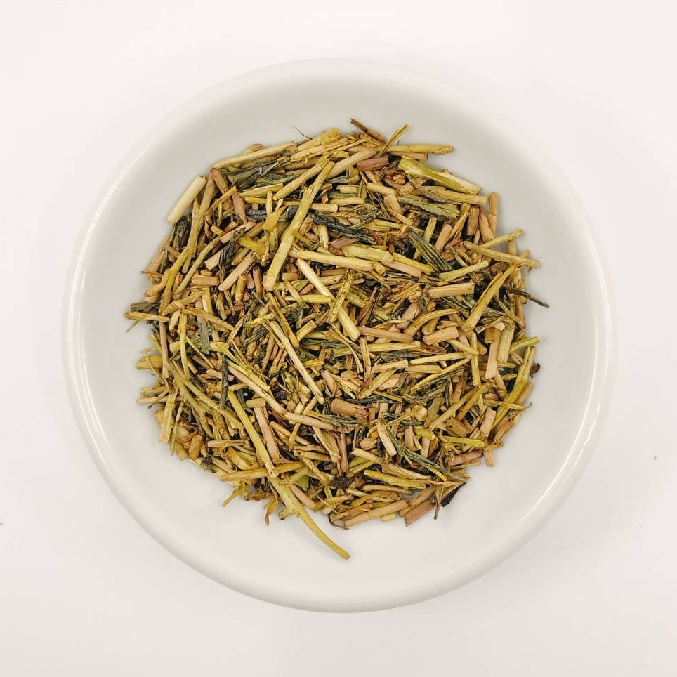 Dry tea leaves on a white plate with a white background