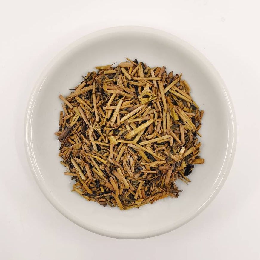 White bowl filled with dried herbs on a white background