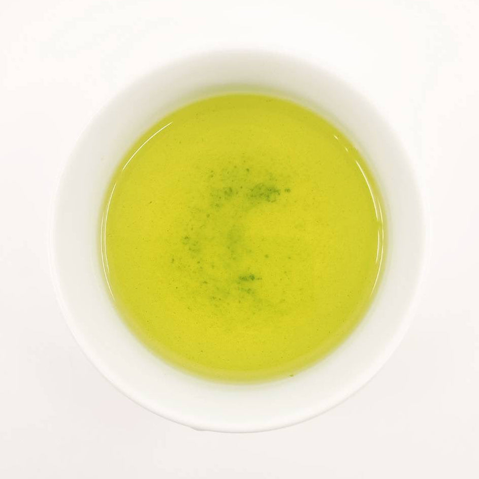 Green tea in a white cup on a white background