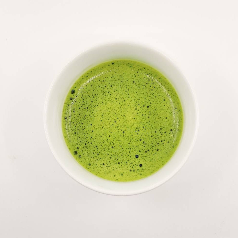 Green smoothie in a white bowl on a white background