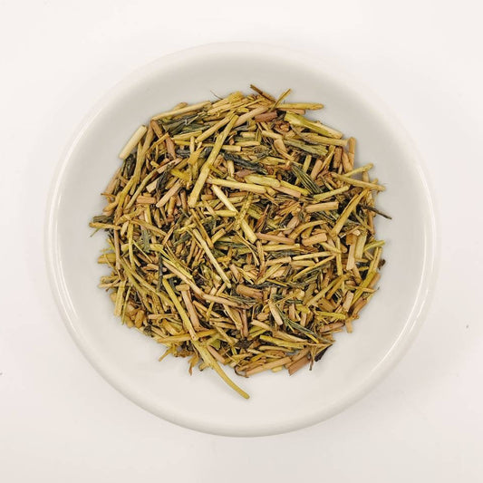 Dry tea leaves on a white plate with a white background