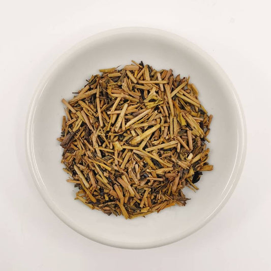 White bowl filled with dried herbs on a white background