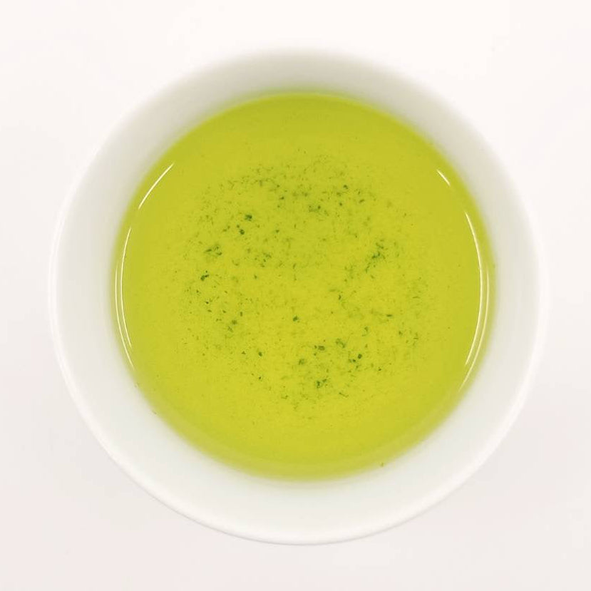 Green tea in a white bowl on a white background
