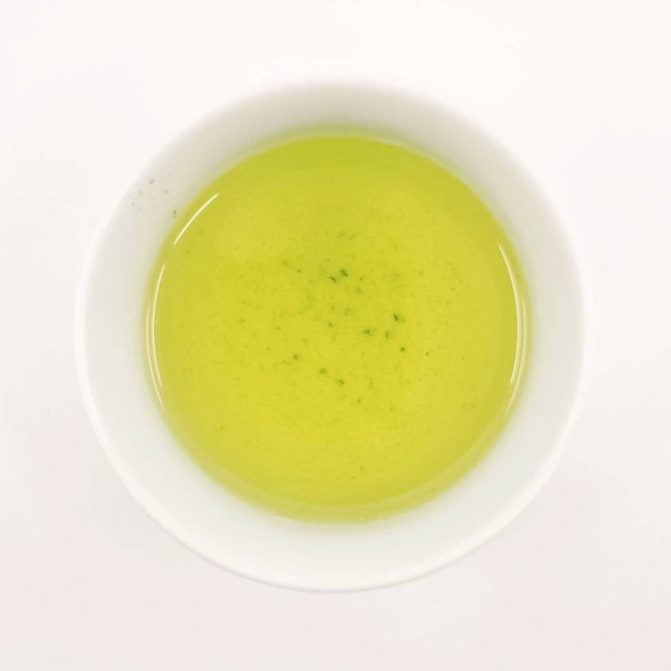 Green tea in a white bowl on a white background