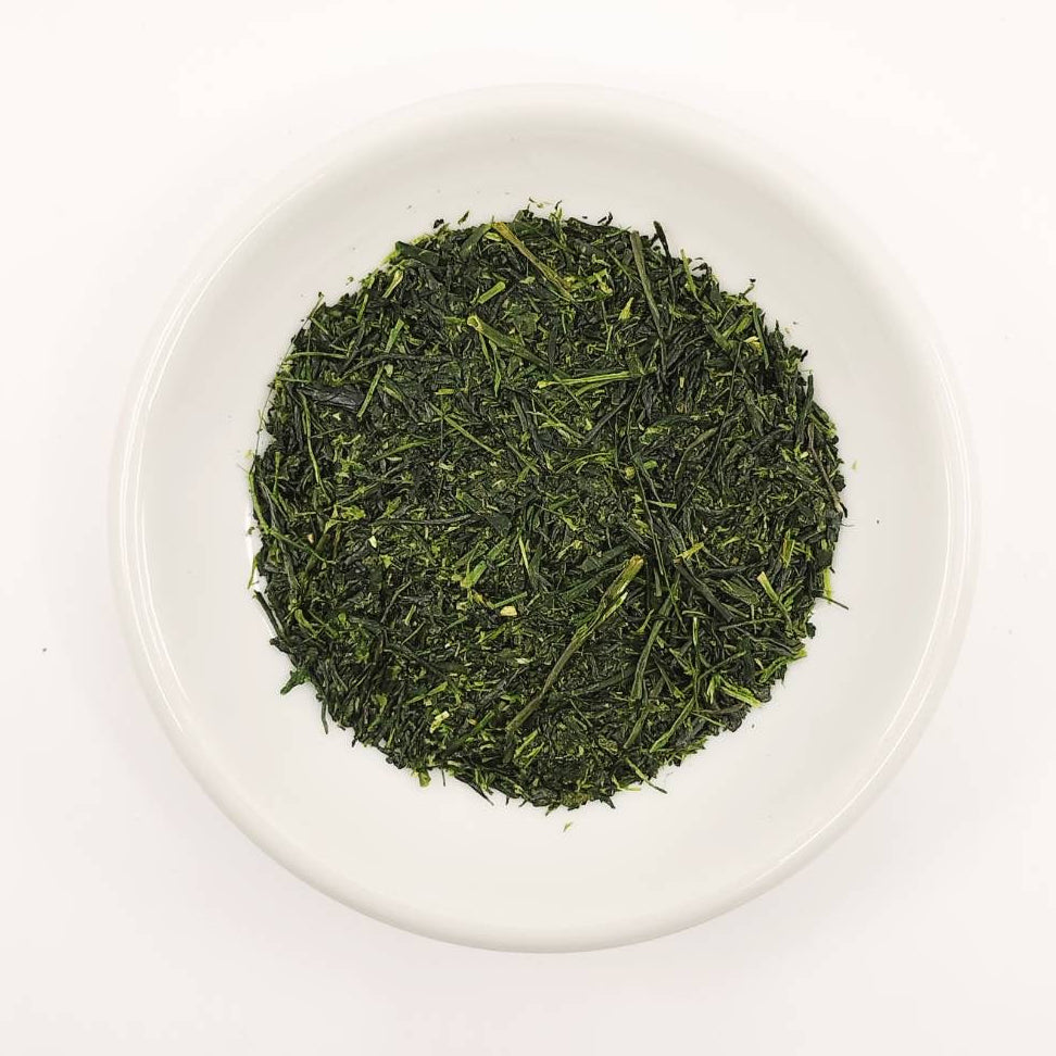 Green tea leaves on a white plate with a white background